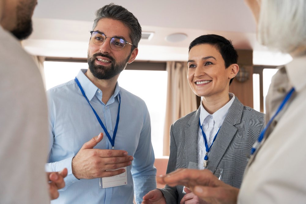 Company supervisors engaging in an inclusive recruitment program workshop, wearing lanyards and participating in a group discussion.