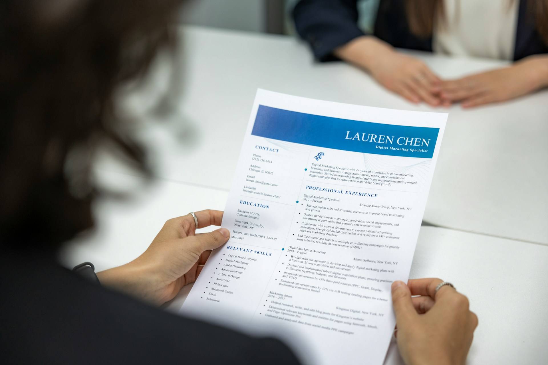 Recruiter reviewing candidate resume using inclusive interviews tip for bias-free screening process.